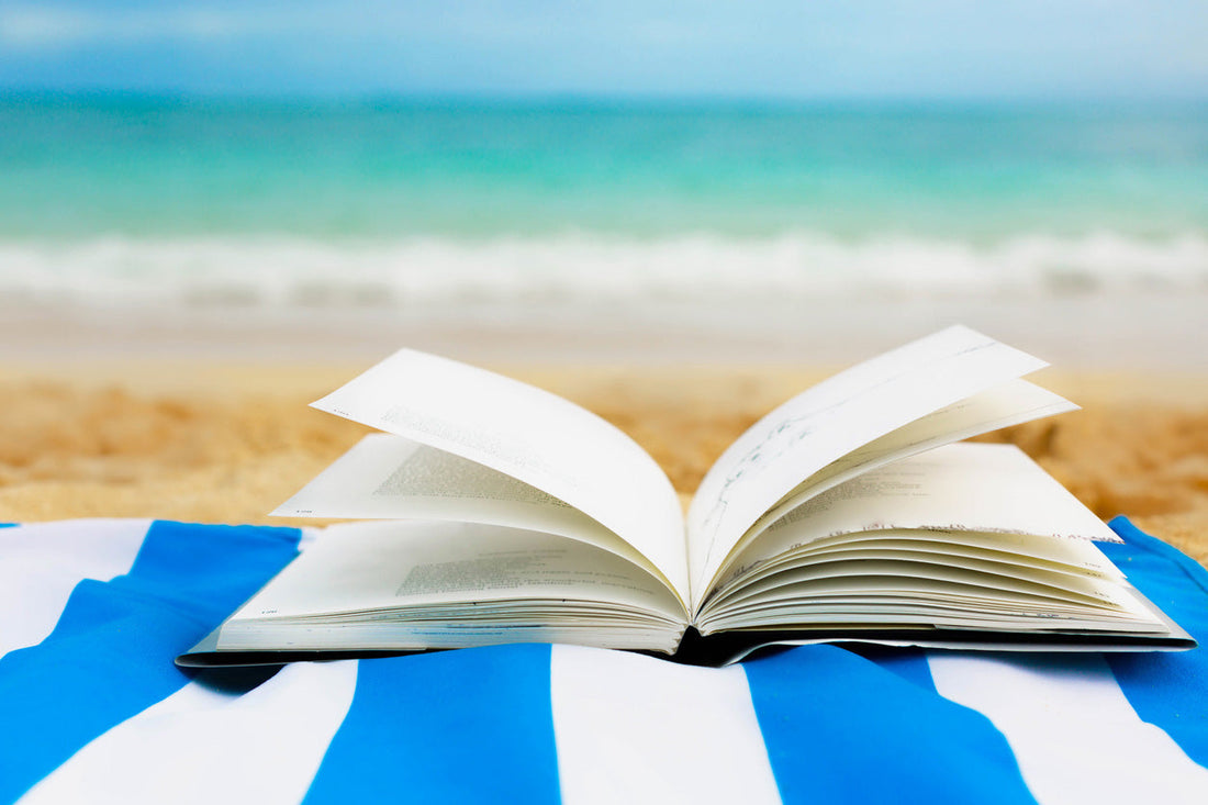 Open book on a towel at the beach