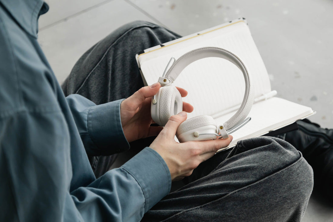 Man holding headphones and notebook