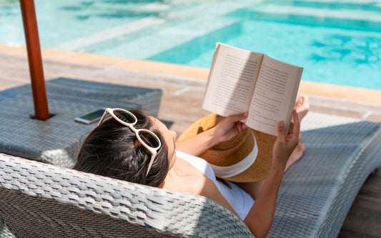 Woman reads a summer book by the pool