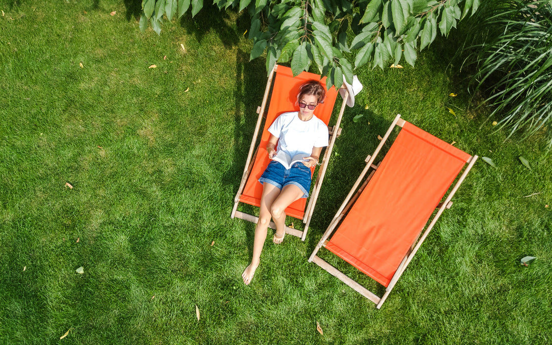Woman reads a summer book on a lawn chair