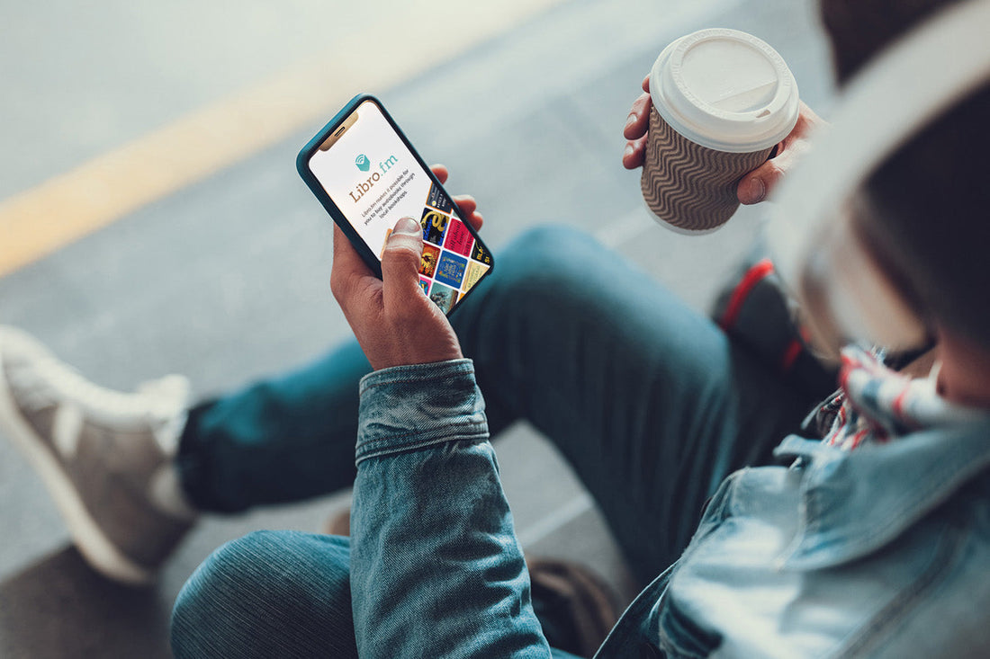 Man listens to Libro.fm on phone with coffee