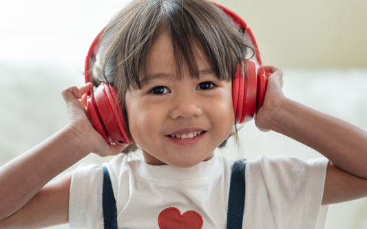 Kid listening to an audiobook with red headphones