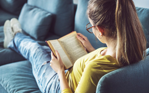 Young woman reads on a couch