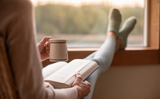 Person relaxes with a new book release and cup of coffee