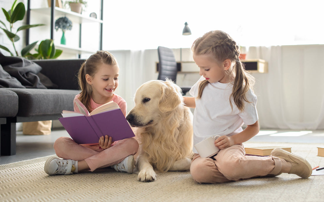Two girls read to their dog