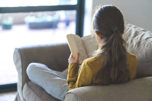 teenager reading on a couch